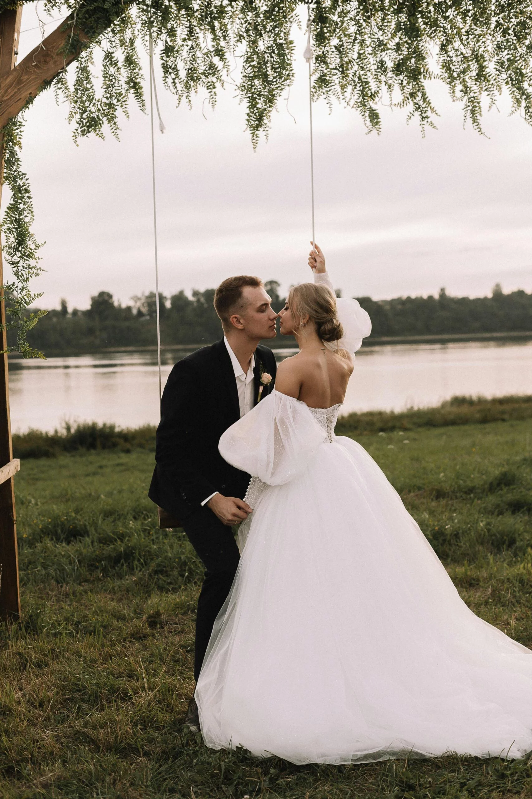 jeune mariés marié et mariée sur balançoire extérieure verdure arbre lac rivière photo jour mariage prestataire photographe wedding designer wedding planner organisateur mariage d'exception bassin du doubs villers le lac suisse